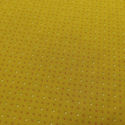 Tecido amarelo mostarda com padrão de pequenos quadrados brancos e vermelhos