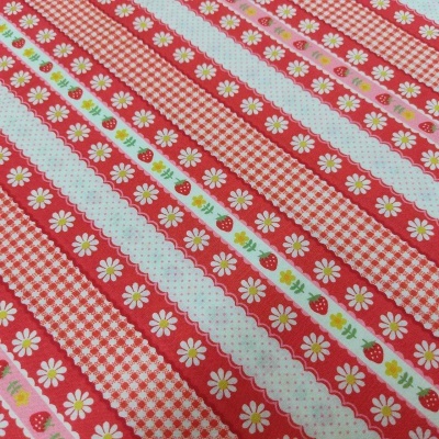 Tecido listrado com padrões florais, morangos e xadrez em vermelho, branco e rosa