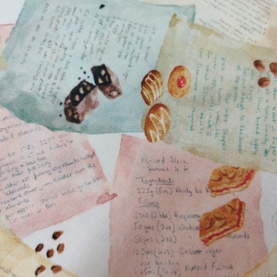 Folhas coloridas com texto manuscrito e desenhos de pães, bolos e grãos de café