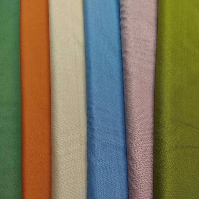 Cinco rolos de tecido coloridos com textura lisa alinhados