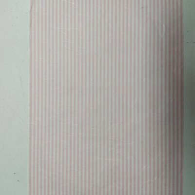 Pano de tecido rosa e branco às riscas verticais sobre superfície branca