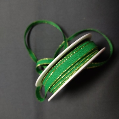 Rolo de fita decorativa verde com linhas douradas