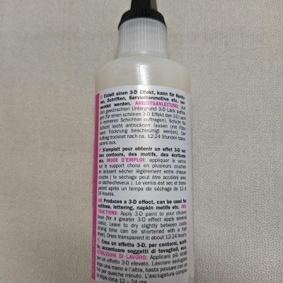 Frasco plástico translúcido com tampa preta e rótulo com instruções em várias línguas