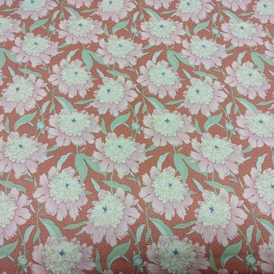 Tecido floral com padrão branco, verde e azul sobre fundo castanho