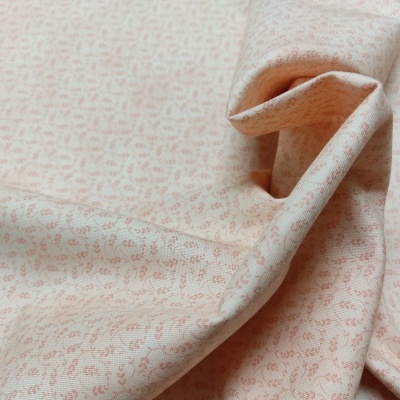 Tecido bege claro com padrão de pequenas flores cor de rosa dobrado