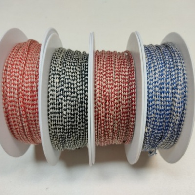 Quatro bobinas de cordões trançados de cores diferentes sobre superfície branca