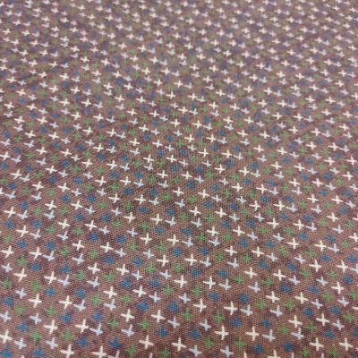 Tecido padrão cruzes brancas e azuis em fundo castanho