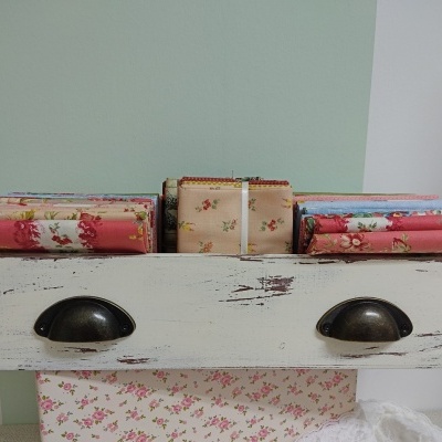 Tecidos floridos organizados em caixa de madeira branca envelhecida