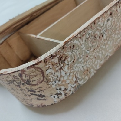 Caixa de madeira decorada com padrões circulares e divisórias internas