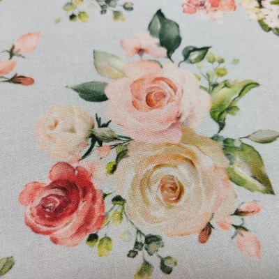 tecido floral com rosas em tons de rosa, creme e vermelho em fundo creme claro