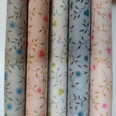 Tecidos enrolados com padrão floral em tons pastel