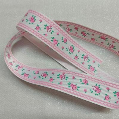 Fita decorativa com padrão floral rosa e verde sobre fundo branco