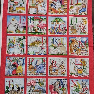 Painel têxtil com letras do alfabeto e animais ilustrados em quadros coloridos.