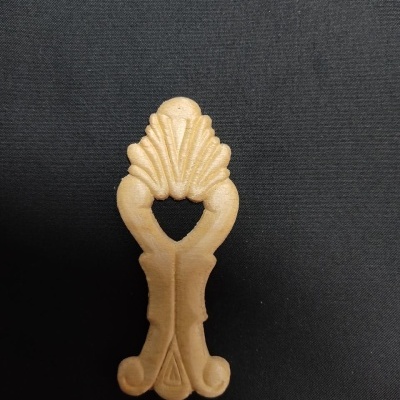 Objeto decorativo em madeira clara com padrão esculpido sobre fundo preto