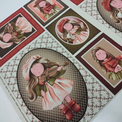 Tecido estampado com ilustrações de bonecas em vários formatos e cores