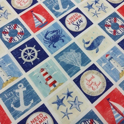 Tecido com padrão náutico azul, vermelho e branco com elementos marítimos e texto.
