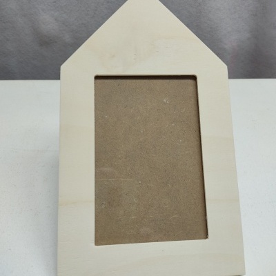 Moldura de madeira clara em forma de casa com espaço retangular vazio