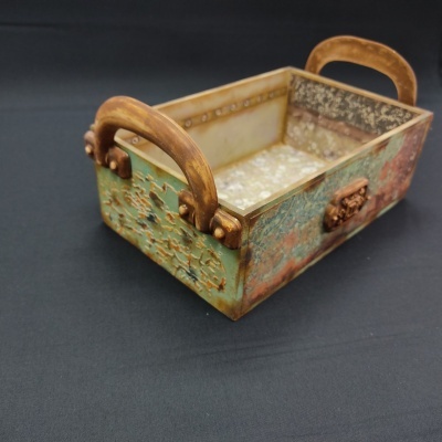 caixa retangular decorativa de metal com alças de madeira em fundo preto