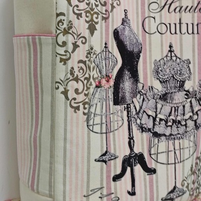 Bolsa de tecido com listras rosa, cinza e bege e desenhos de manequins com texto Haute Couture