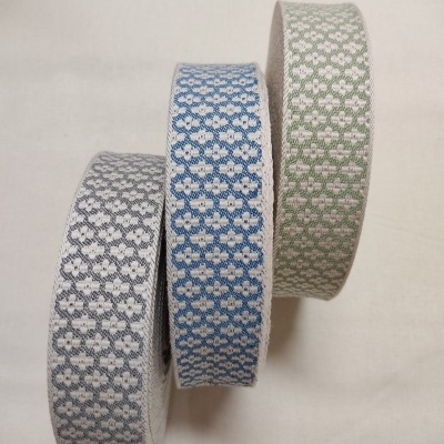 Três rolos de fita têxtil com padrão floral em cinzento, azul e verde
