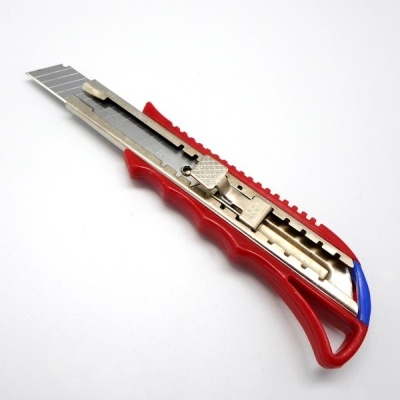 Estilete de plástico vermelho e azul com lâmina metálica