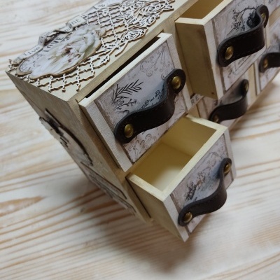 Móvel decorativo em madeira com gavetas pequenas e puxadores em couro