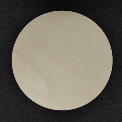 Prato redondo de madeira clara sobre superfície escura