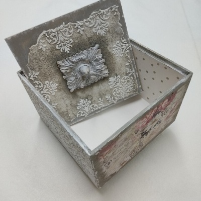 Caixa decorativa de madeira com tampa aberta e padrão floral em relevo