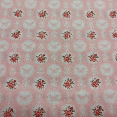 Tecido rosa claro com padrão de borboletas e flores em círculos brancos.
