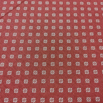 Tecido vermelho com padrão branco repetido