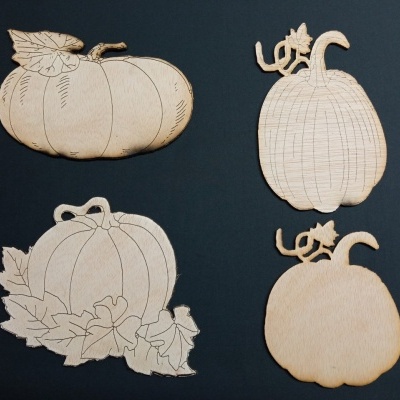 Decorações em madeira em forma de abóboras com padrões entalhados e cor natural