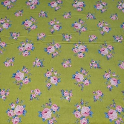 Tecido verde com padrão floral de pequenos buquês cor-de-rosa e lilás