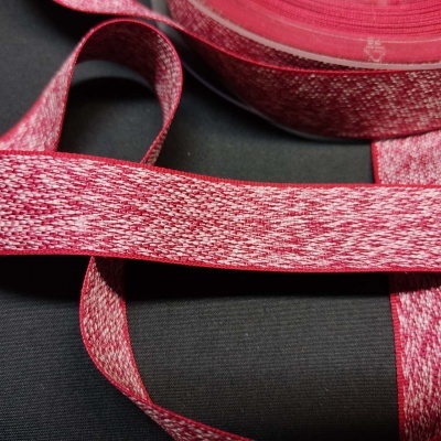 Fita têxtil vermelha e branca com padrão mesclado sobre superfície preta