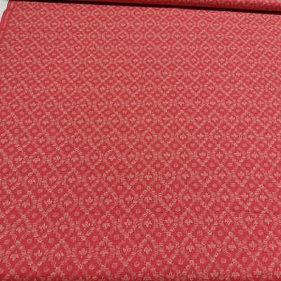 Tecido vermelho com padrões florais claros e textura visível