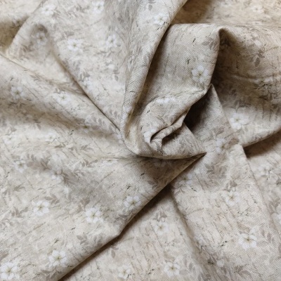 Tecido bege com padrão floral branco e cinza claro