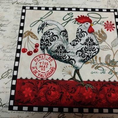 Tecido com desenho de galo estilizado e selo postal vermelho no fundo com texto cursivo.