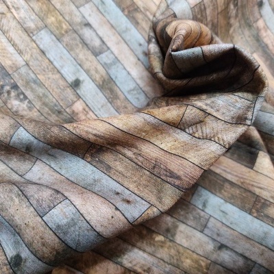 tecido estampado com padrão de ripas de madeira em tons castanho e cinza sobre superfície semelhante