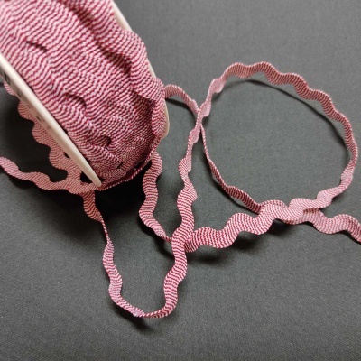 Fita de ziguezague rosa e branca sobre superfície preta