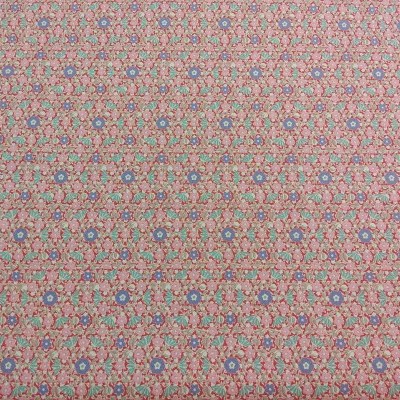 Tecido com padrão floral repetitivo em azul, vermelho e verde sobre fundo bege