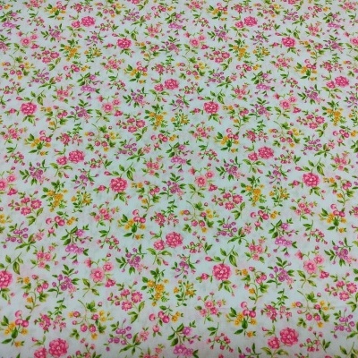 Tecido floral branco com flores rosas, amarelas e folhas verdes