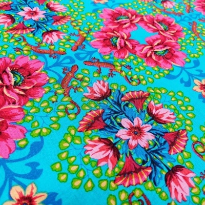 Tecido com padrão floral colorido em fundo azul e verde