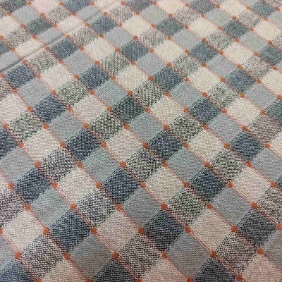 Tecido com padrão de quadrícula azul e cinza com pontos laranja