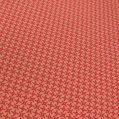 Tecido bege com padrão repetitivo de flores vermelhas pequenas