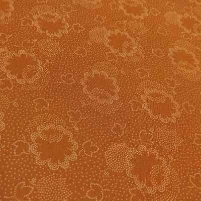 Tecido laranja com padrão floral pontilhado branco