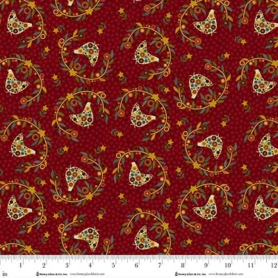 Tecido vermelho com padrão de pássaros e flores coloridas e régua para escala.