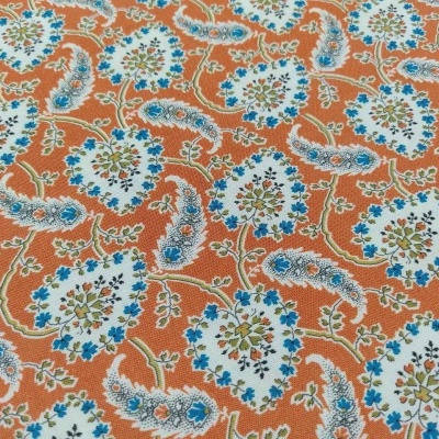 Tecido laranja com padrão floral azul, verde e branco