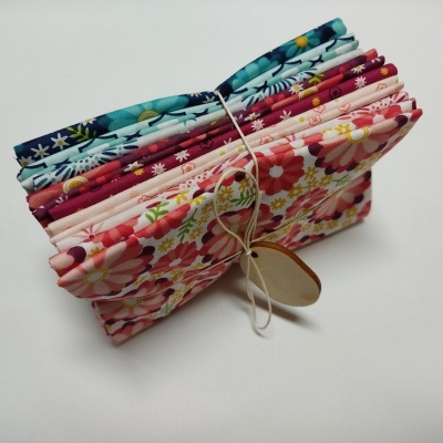 Conjunto de tecidos dobrados com padrões florais e etiqueta amarrados com corda