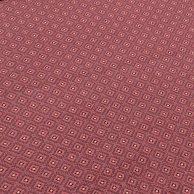 Tecido com padrão de quadrados em tons de vermelho e rosa