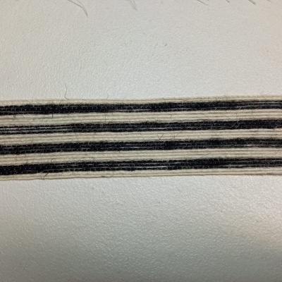 Fita listrada preta e cinza sobre superfície clara com texto SHOT ON REDMI 9 AI QUAD CAMERA