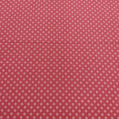 Tecido vermelho com padrão repetido de losangos e pontos brancos